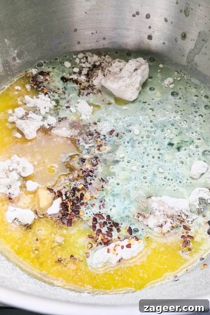 Wild Garlic & Cheddar Savory Hot Cross Buns 3 All the dry and wet ingredients for wild garlic hot cross buns are combined in a large silver mixing bowl, ready for kneading.