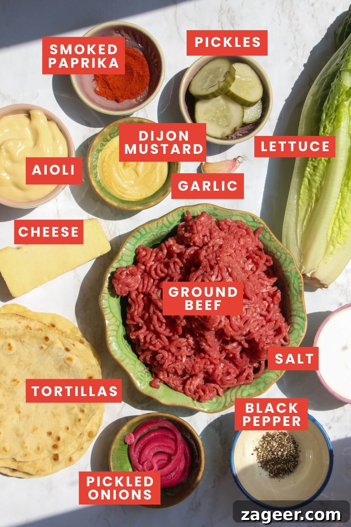 Big Mac Smash Burger Taco Fusion 3 All the essential ingredients for making Big Mac tacos, neatly arranged and labelled on a pristine white marble countertop. Includes ground beef, mini tortillas, fresh lettuce, pickles, cheese, and components for the homemade Big Mac sauce.