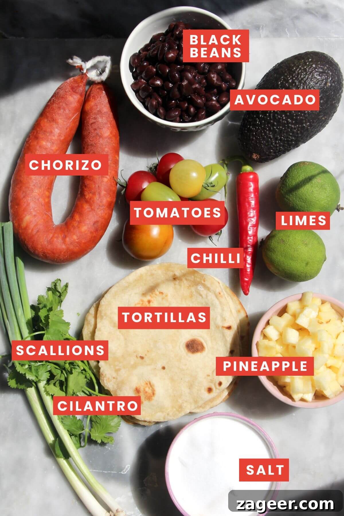 Spicy Chorizo and Black Bean Tacos with Sweet Pineapple Salsa 3 All the fresh and pantry ingredients for chorizo black bean tacos, neatly laid out on a stylish grey marble background, ready for preparation.