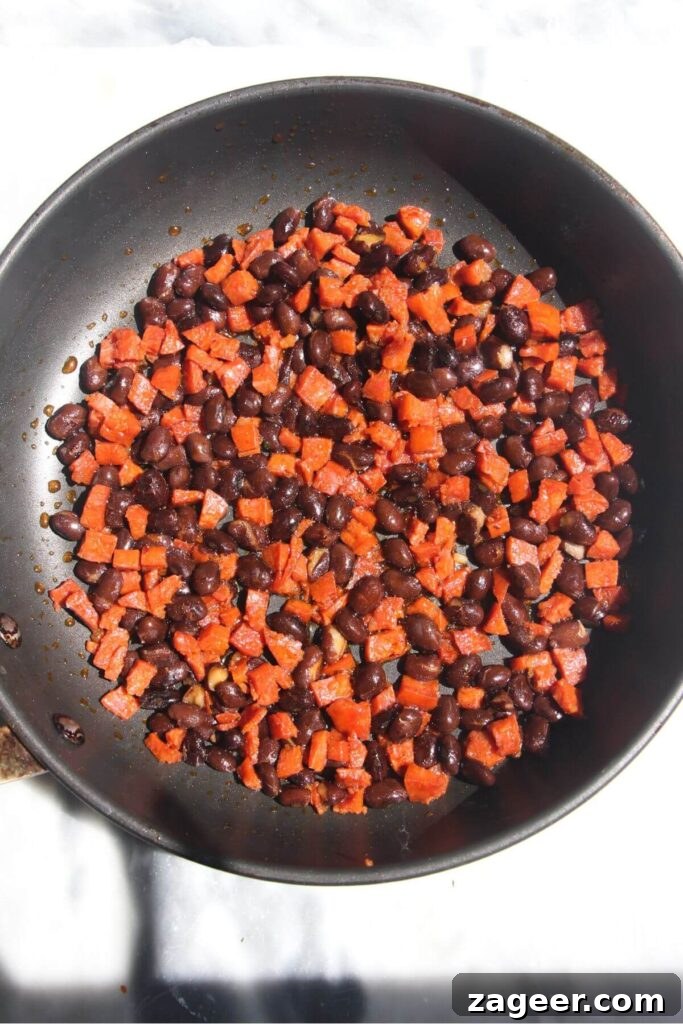 Spicy Chorizo and Black Bean Tacos with Sweet Pineapple Salsa 7 A delicious mix of diced chorizo and black beans, coated in smoky oil, cooked together in a small black pan.