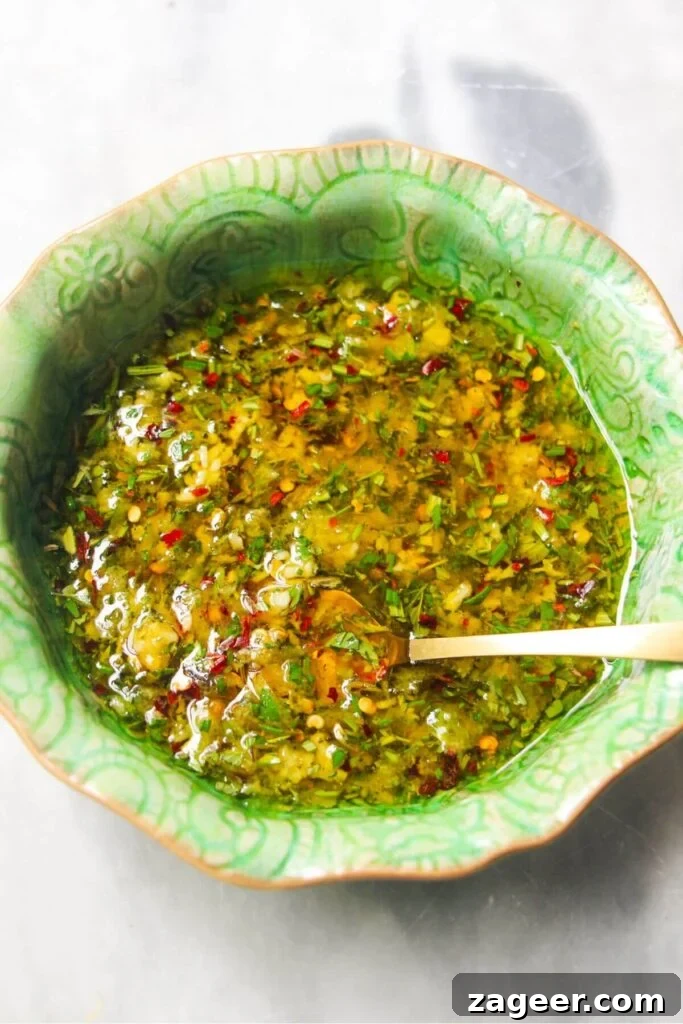 Zesty Olives in Minutes 4 Olive marinade mixed in a small green bowl, showing oil, herbs, and lemon zest.
