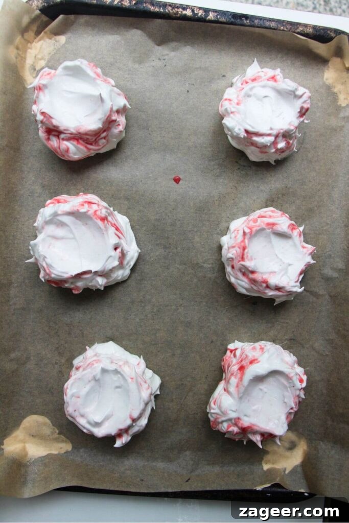 Heavenly Berry Ripple Cheesecake Pavlova Bites 12 6 berry ripple pavlovas on a baking paper lined tray, pre-baking.