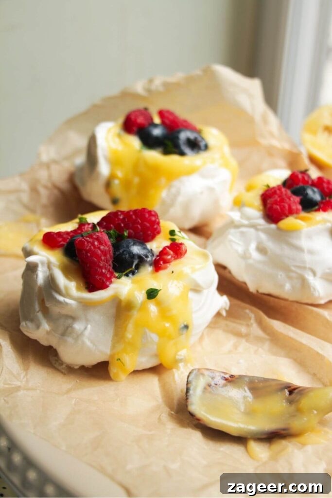 Heavenly Berry Ripple Cheesecake Pavlova Bites 24 Close up of passionfruit and lemon curd topped pavlovas with berries on top.