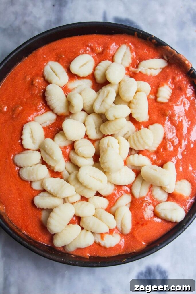 Creamy One-Pot Sausage Gnocchi Delight 7 Pillowy gnocchi are gently introduced into the rich, creamy tomato sauce in the pan, ready to absorb all the delicious flavors.