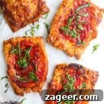 Four upside down puff pastry pizza tarts on baking paper, with a small bowl of chilli jam on the side.