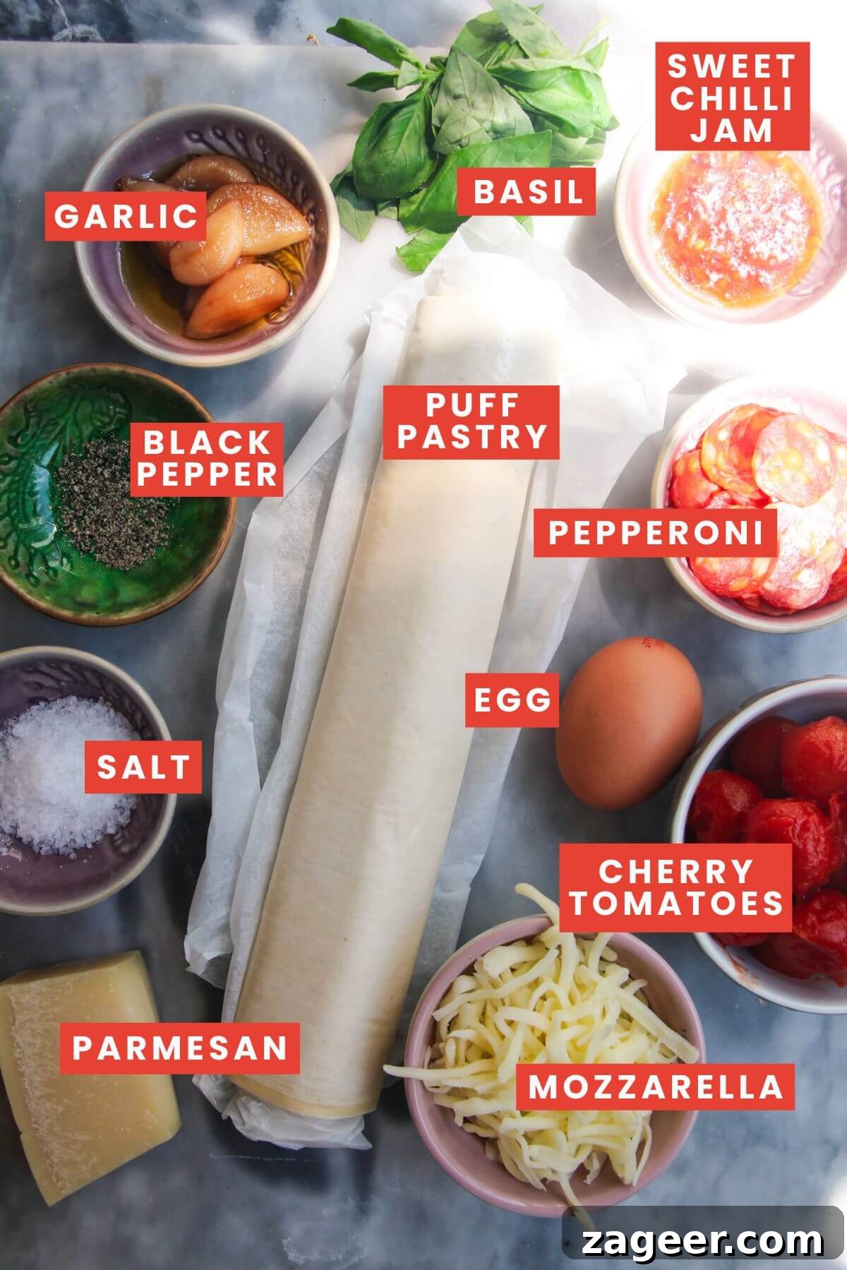 Puff Pastry Pizza Flips 3 A curated selection of ingredients for upside down puff pastry tarts, neatly arranged and labeled on a stylish grey marble background, highlighting their freshness and quality.