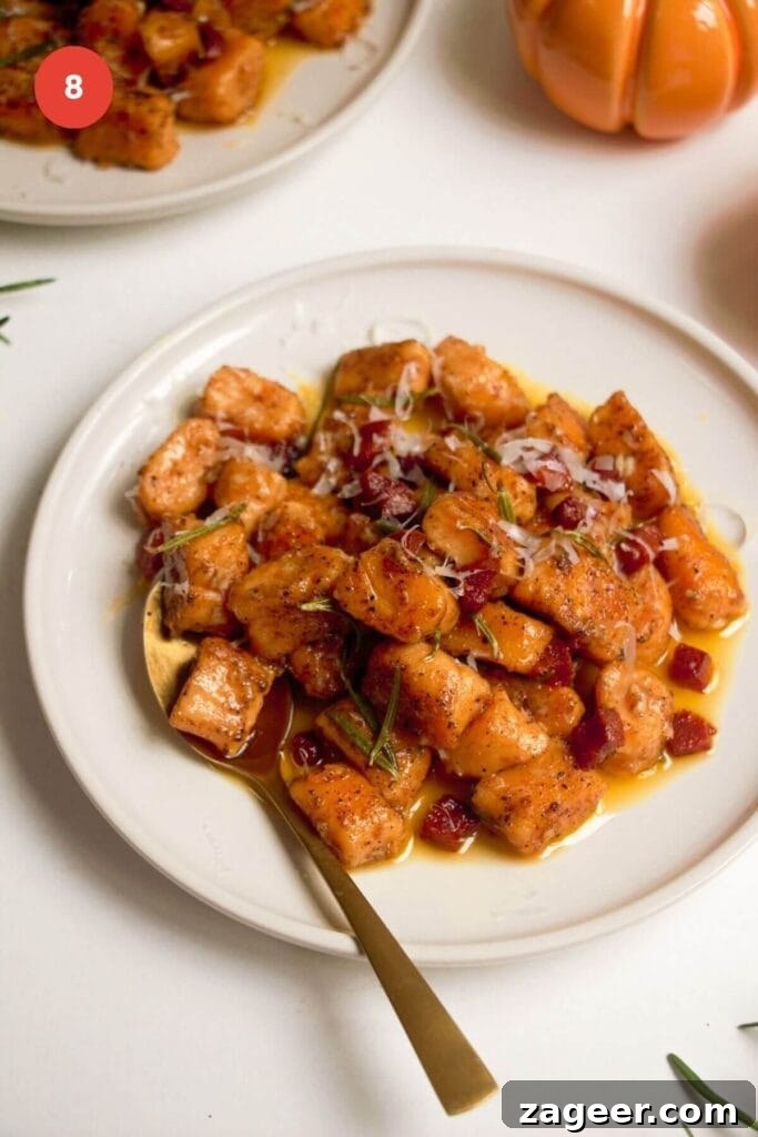 Effortless 5-Ingredient Sweet Potato Gnocchi 11 Sweet potato gnocchi served on a plate in brown butter sauce with chorizo.