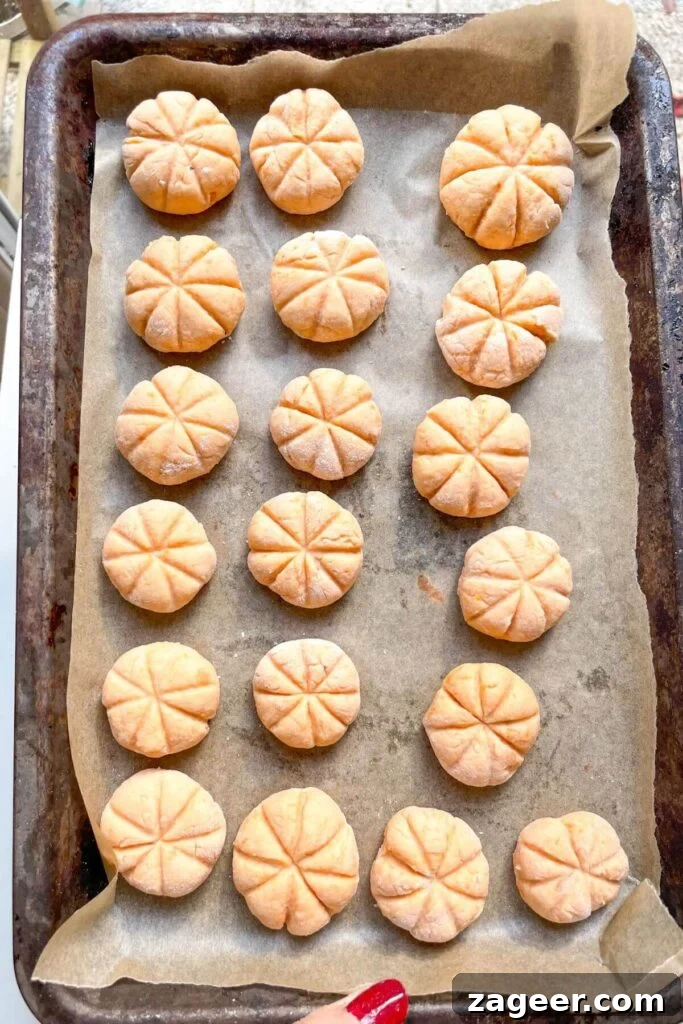 Effortless 5-Ingredient Sweet Potato Gnocchi 13 Pumpkin shaped gnocchi on a lined tray.