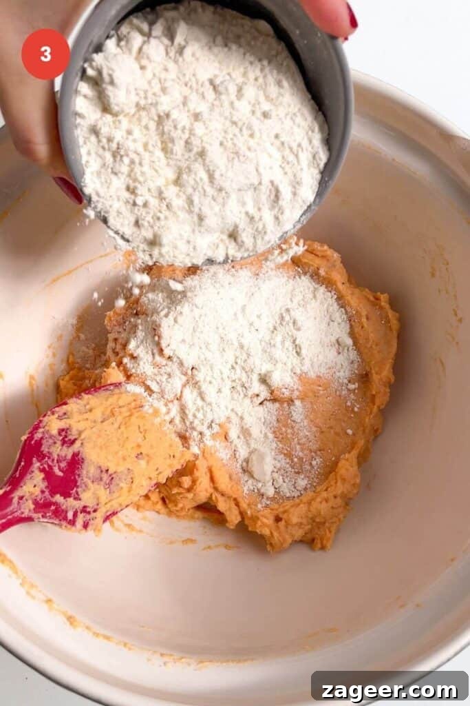 Effortless 5-Ingredient Sweet Potato Gnocchi 6 Flour being added to sweet potato gnocchi dough in mixing bowl.