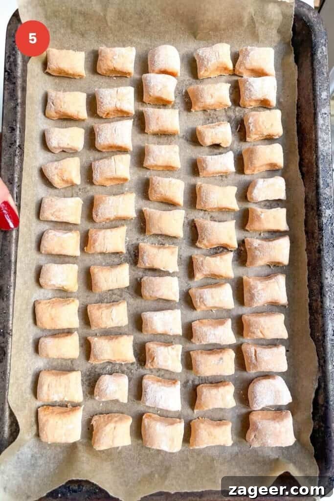 Effortless 5-Ingredient Sweet Potato Gnocchi 8 Sweet potato gnocchi on a lined tray.