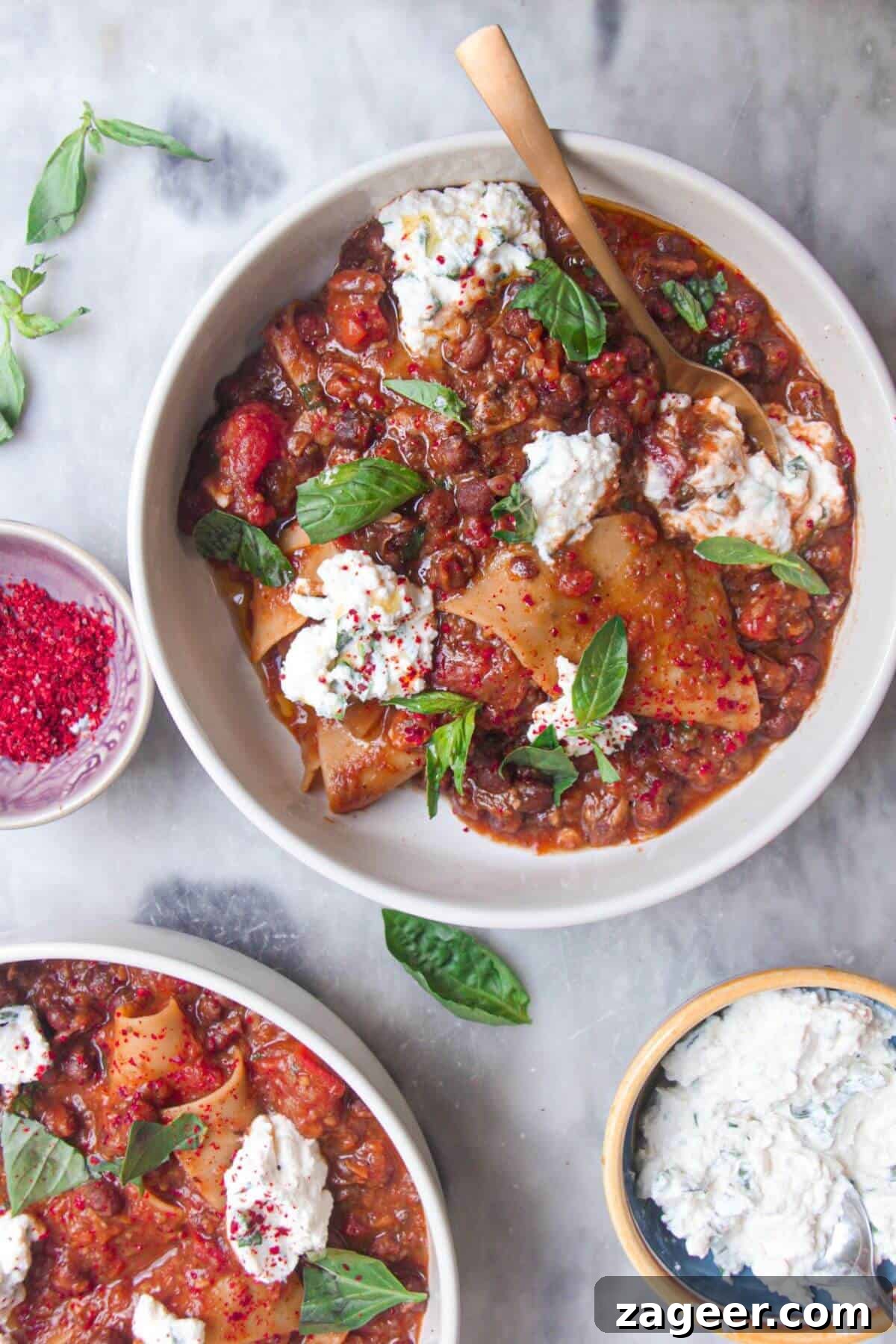 Stealthy Veggie One Pot Lasagna Soup 2 Two bowls of vegetarian lasagna soup, garnished with creamy ricotta and fresh basil.