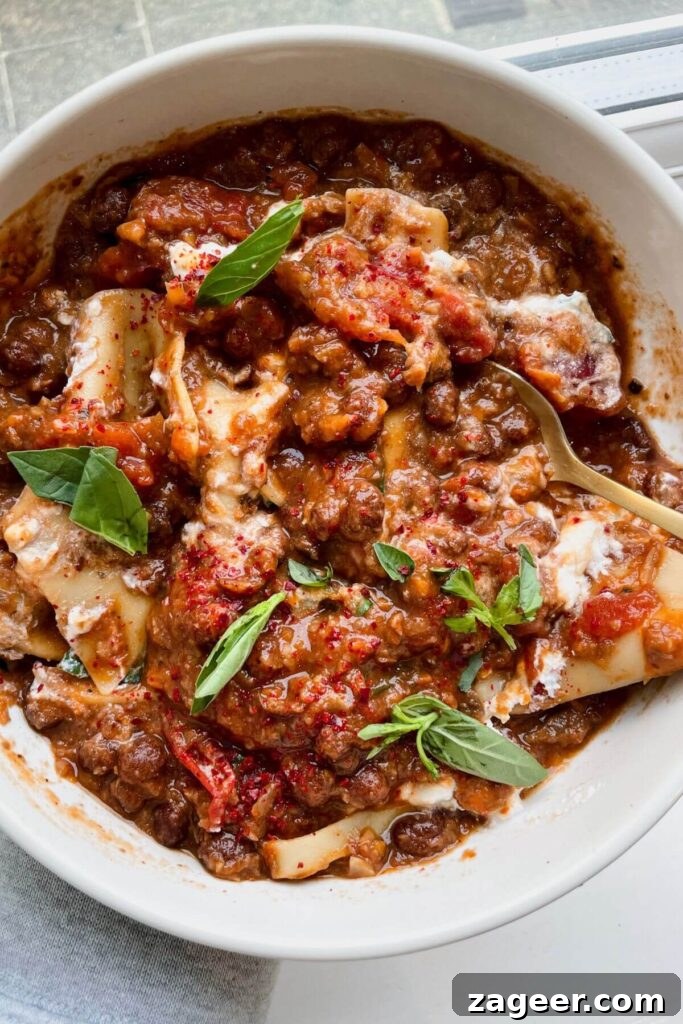 Stealthy Veggie One Pot Lasagna Soup 13 Holding a bowl of lasagna soup with basil and ricotta on top, showcasing a perfect meal.