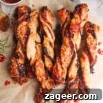 A pile of bacon, blue cheese and sweet chilli twists on a sheet of baking paper.
