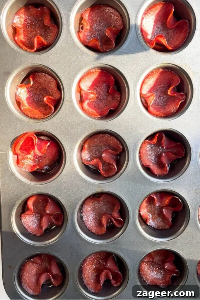 Loaded Antipasto Salami Crisps 5 Crispy, golden-brown salami cups perfectly formed in a mini muffin tin after baking.