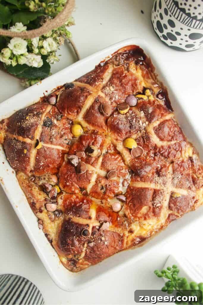 A baked hot cross bun bread and butter pudding presented beautifully in a white baking dish, ready to be served.