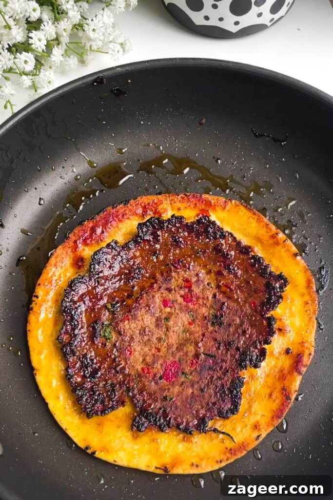 Effortless Lahmacun Smash Tacos 7 Lahmacun taco sizzling and cooking in a small pan, meat side down, achieving a perfect char.