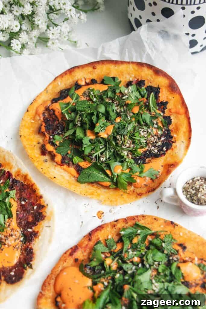 Effortless Lahmacun Smash Tacos 9 A fully assembled Smash Lahmacun Taco, garnished with red pepper sauce and herby salad, showcasing its delicious layers.