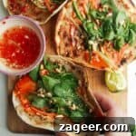 Three chicken banh mi tacos on a wooden board.