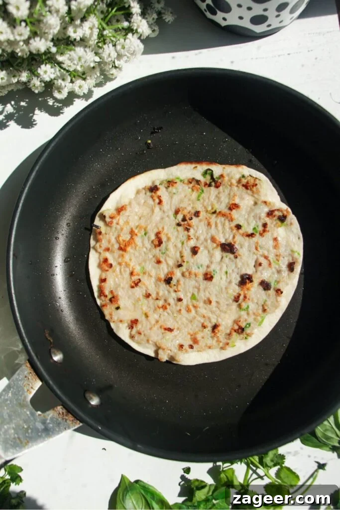 Smashed Banh Mi Tacos 6 A banh mi taco cooking chicken-side down in a hot frying pan.