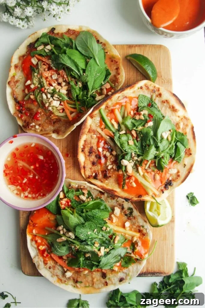 Smashed Banh Mi Tacos 9 Another view of three chicken banh mi tacos on a wooden board, highlighting the fresh ingredients.