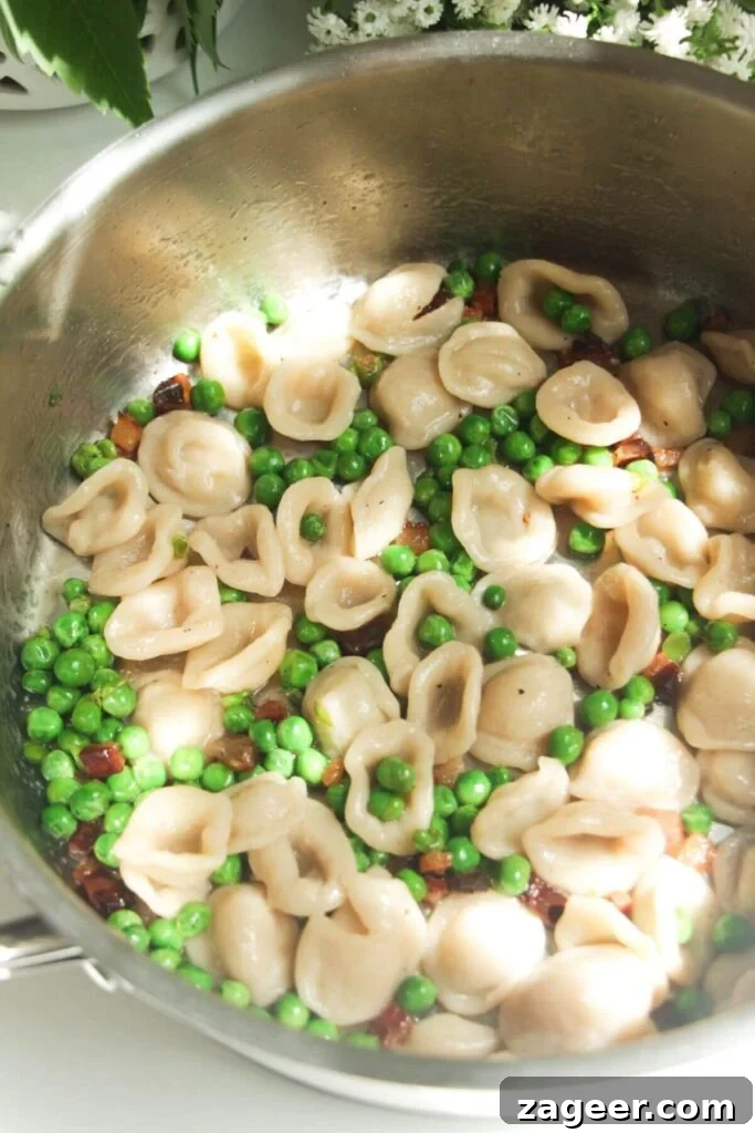 Silky Pancetta, Pea, and Spinach Pasta 8 Cooked pasta thoroughly tossed through the peas and pancetta in a pan, ensuring every piece is coated with flavor.