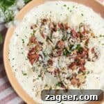 Creamy Chicken Caesar dip mixed and topped generously with extra chicken and bacon pieces.
