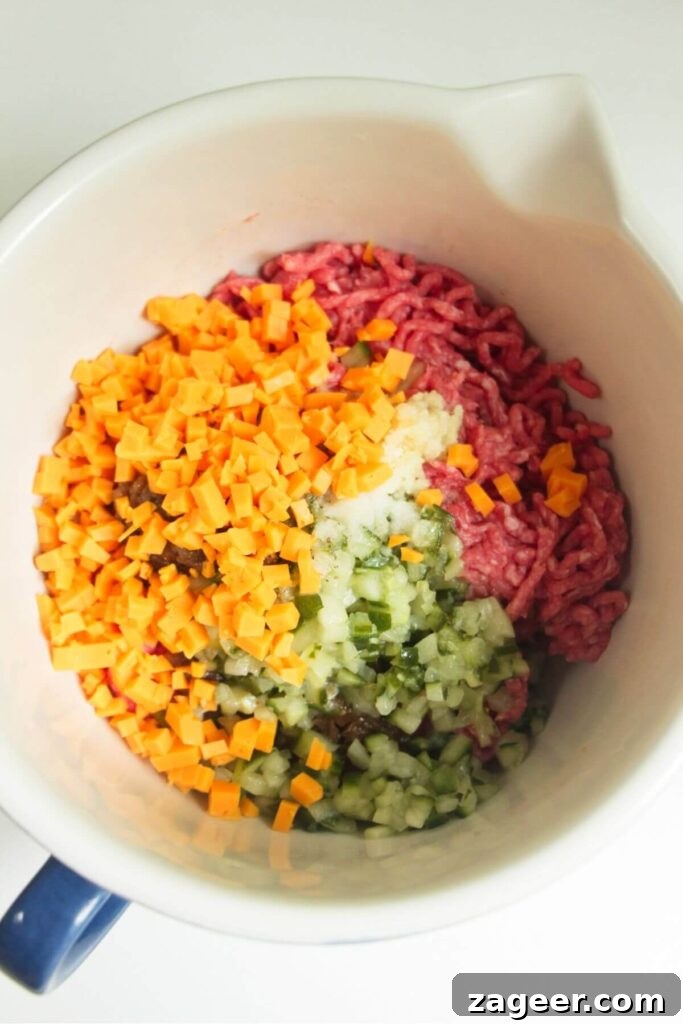 Smashed Cheeseburger Tacos 4 A mixing bowl filled with ground beef, vibrant yellow cheese, and green pickles, ready to be combined for the cheeseburger topping.