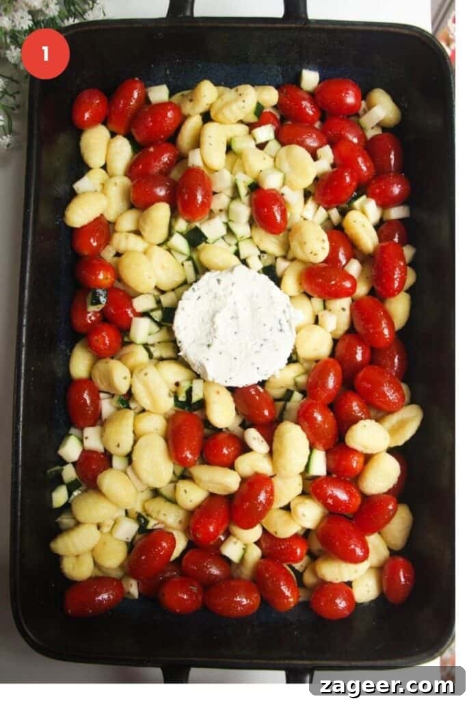 One Pan Creamy Boursin Gnocchi Bake 4 Gnocchi, tomatoes, zucchini, and Boursin arranged in a baking dish before cooking.
