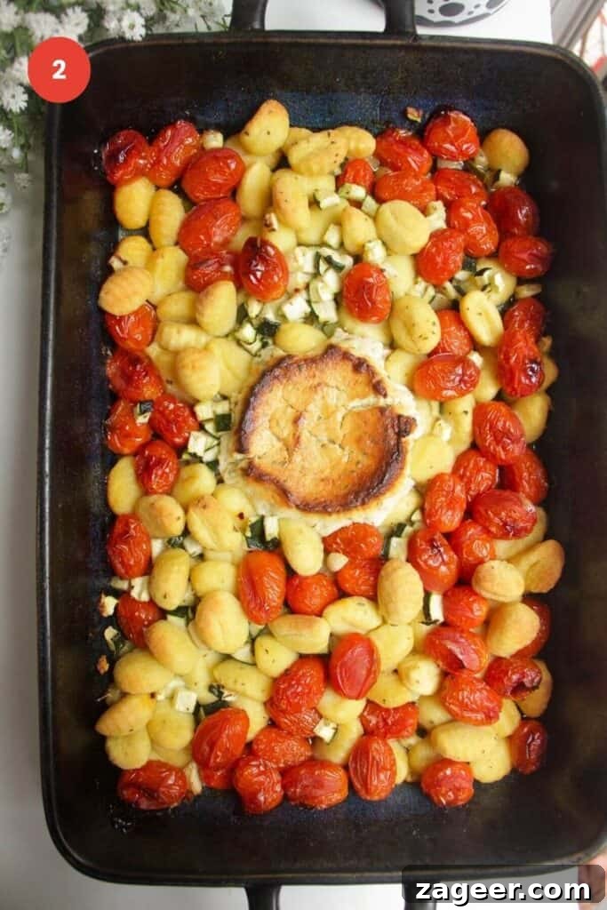 One Pan Creamy Boursin Gnocchi Bake 5 Baked tomatoes, zucchini, Boursin, and gnocchi bubbling in a baking dish after cooking.
