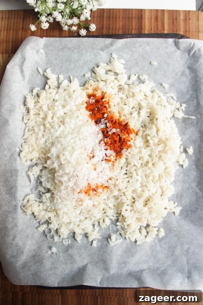 Chicken Caesar Crispy Rice Power Bowl 4 Rice mixed with paprika and parmesan, spread on an oven tray, ready for baking.