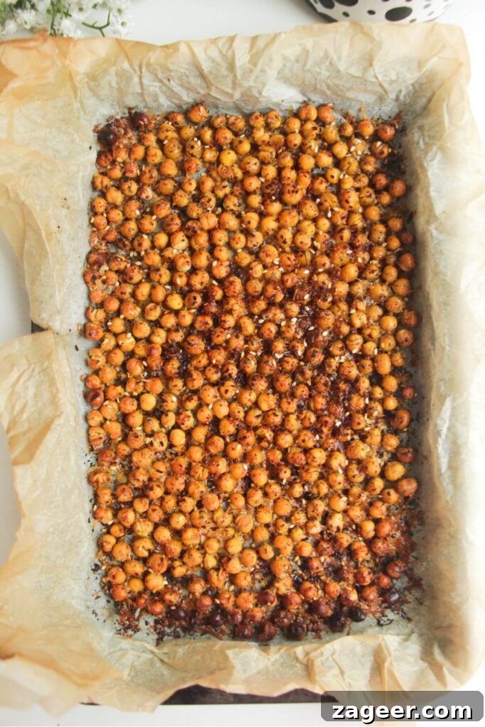 Chicken Caesar Crispy Rice Power Bowl 7 Golden, crispy chickpeas cooling on a baking paper-lined tray after roasting.