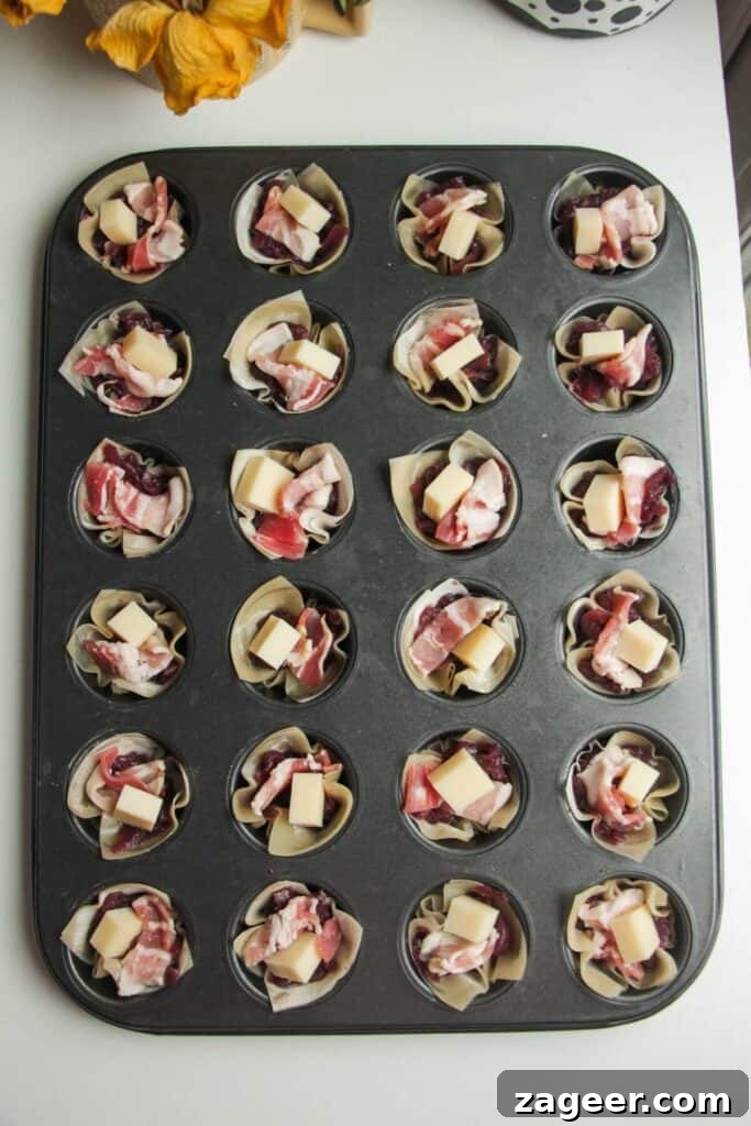 Sweet and Savory Bacon Gruyère Phyllo Tartlets 5 Caramelized onion, Gruyere cheese, and bacon filling being added to phyllo cups in a mini muffin pan.