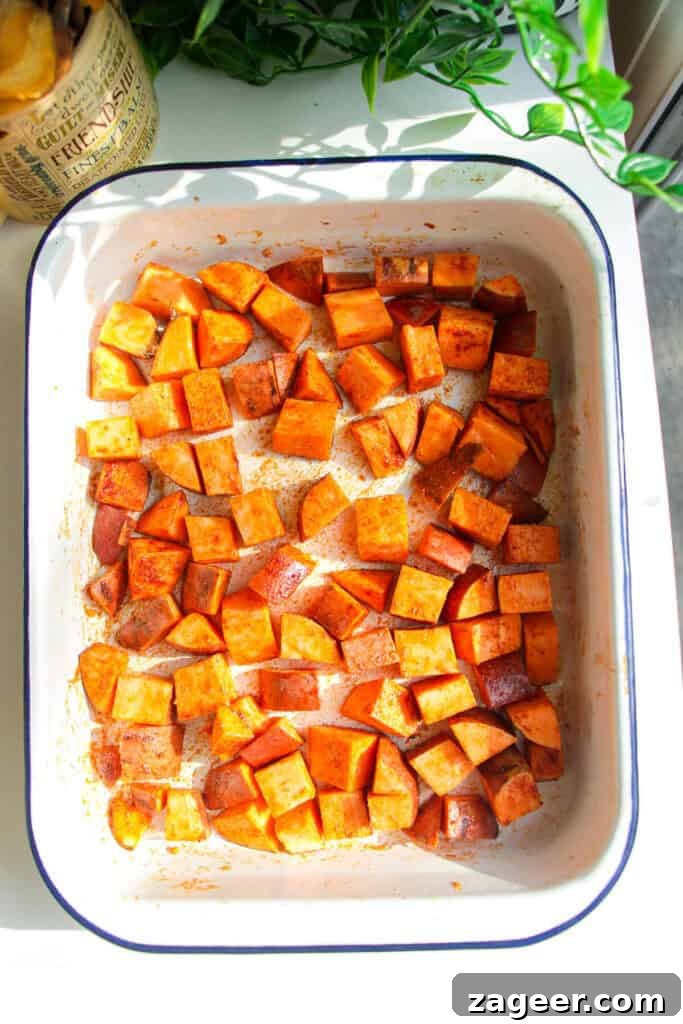 Trending Beef Power Bowls with Sweet Potato & Creamy Cottage Cheese 4 Diced sweet potato tossed with spices in an oven tray, ready for roasting.