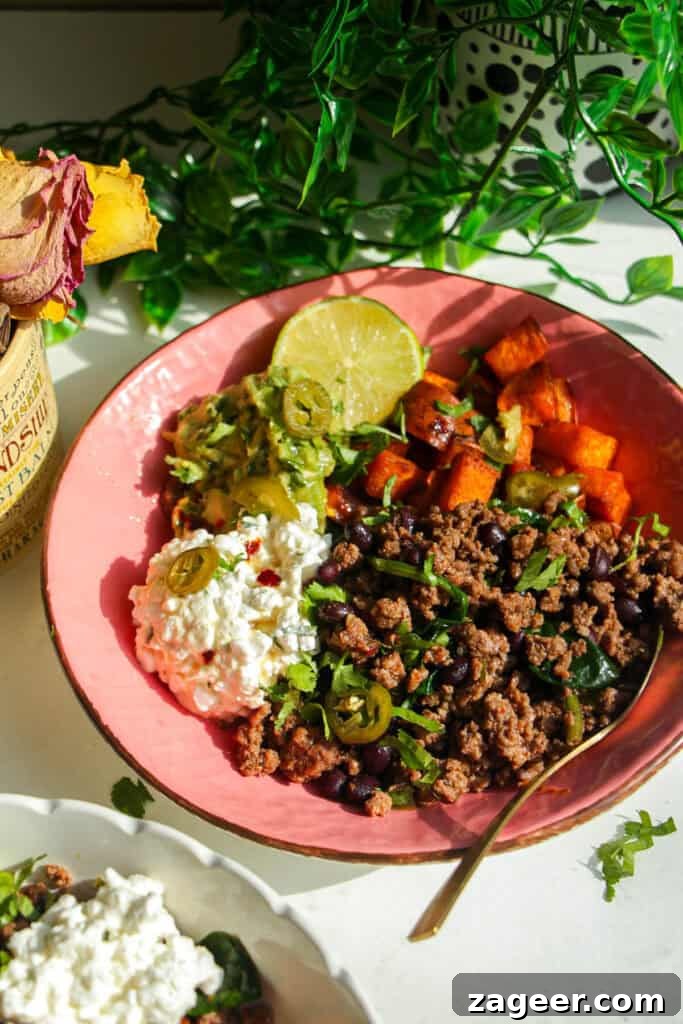 Trending Beef Power Bowls with Sweet Potato & Creamy Cottage Cheese 9 A beautifully assembled taco beef protein bowl with a lime wedge and golden spoon, ready to eat.