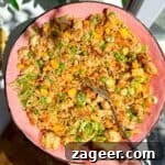Hand holding pink bowl filled with fried rice.
