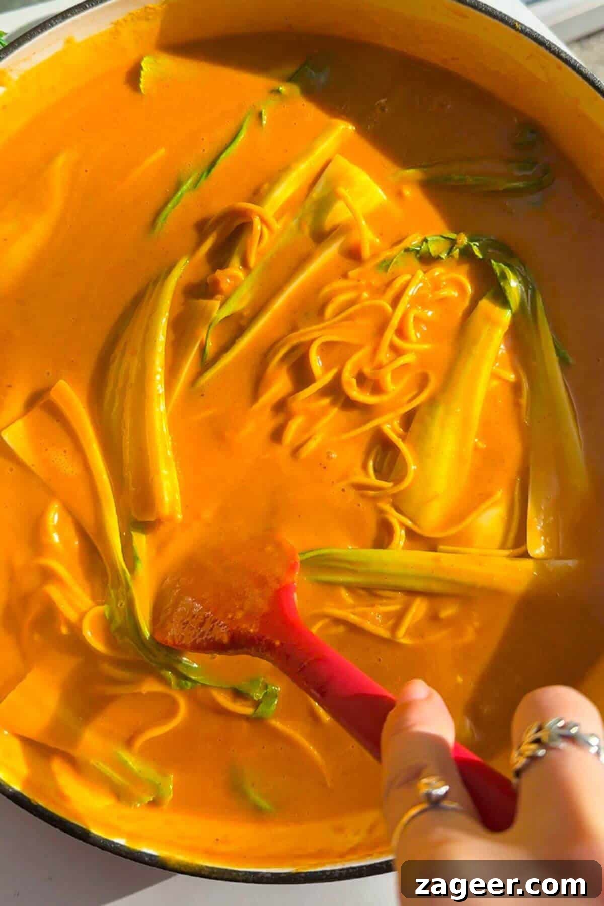 Velvety One-Pot Coconut Butternut Ramen 11 Stirring bok choi through butternut noodles.