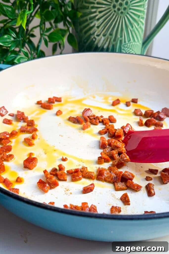 Velvety One-Pot Coconut Butternut Ramen 5 Cooking chorizo in large pan.