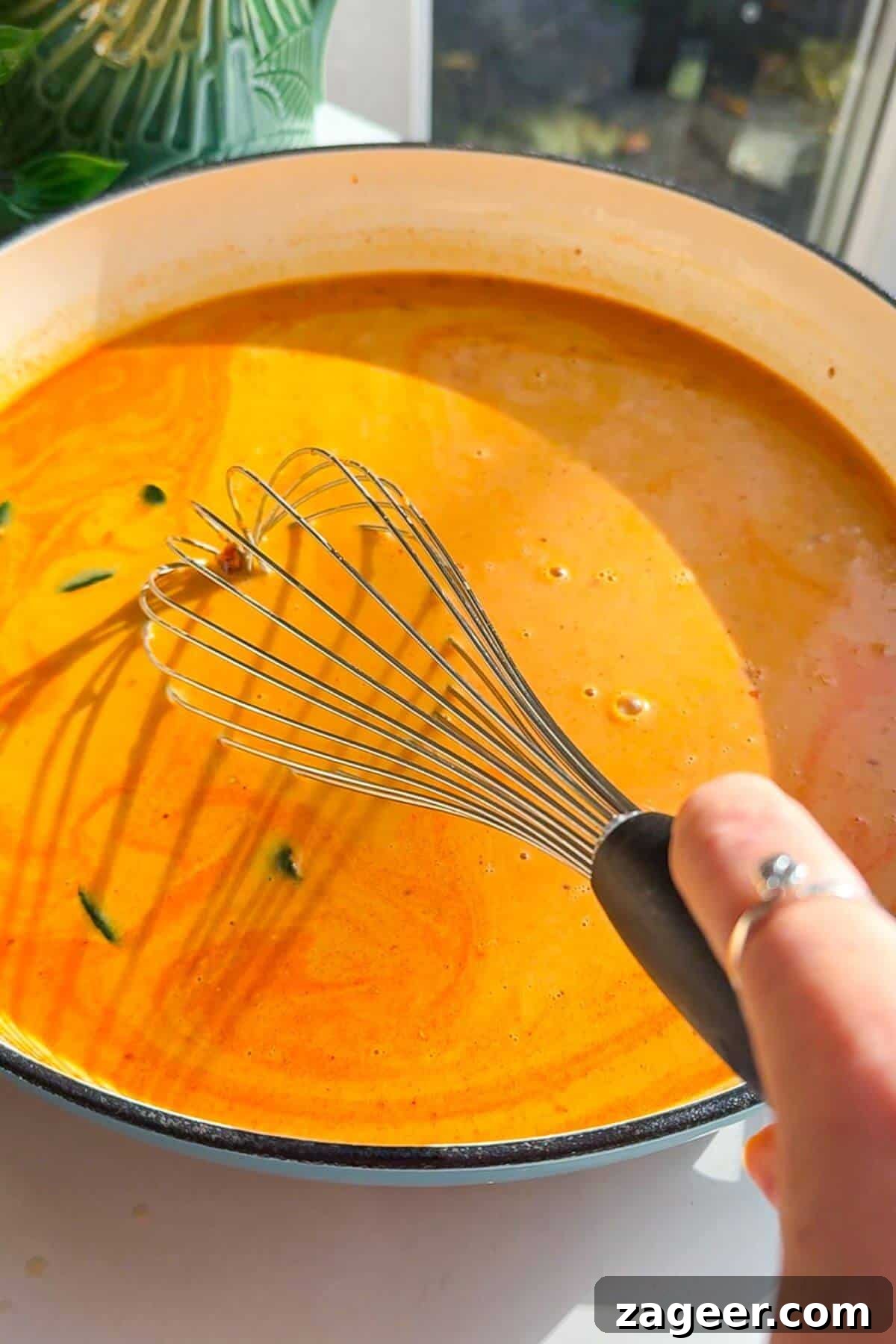 Velvety One-Pot Coconut Butternut Ramen 7 Whisking coconut gochujang broth in pan.