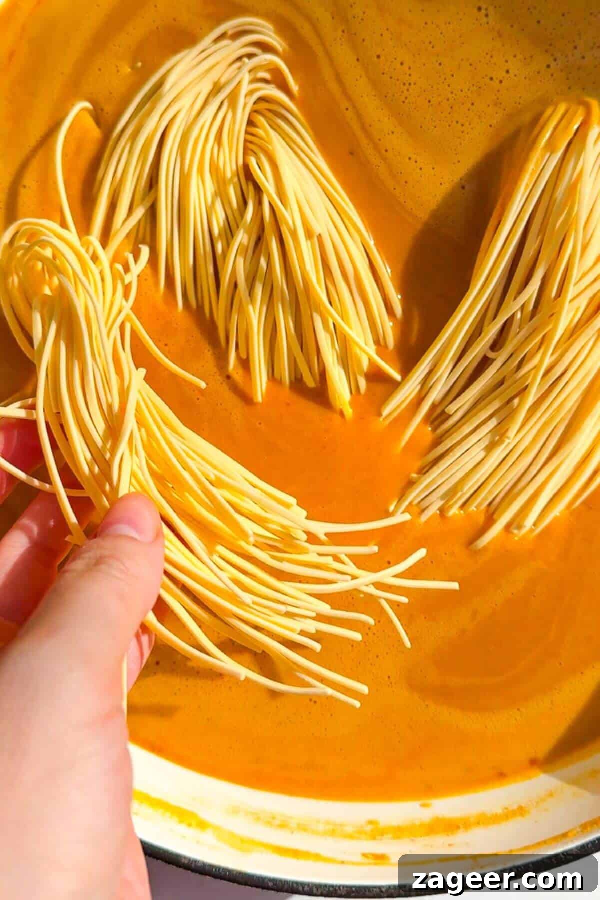 Velvety One-Pot Coconut Butternut Ramen 10 Adding noodles to butternut squash coconut broth.