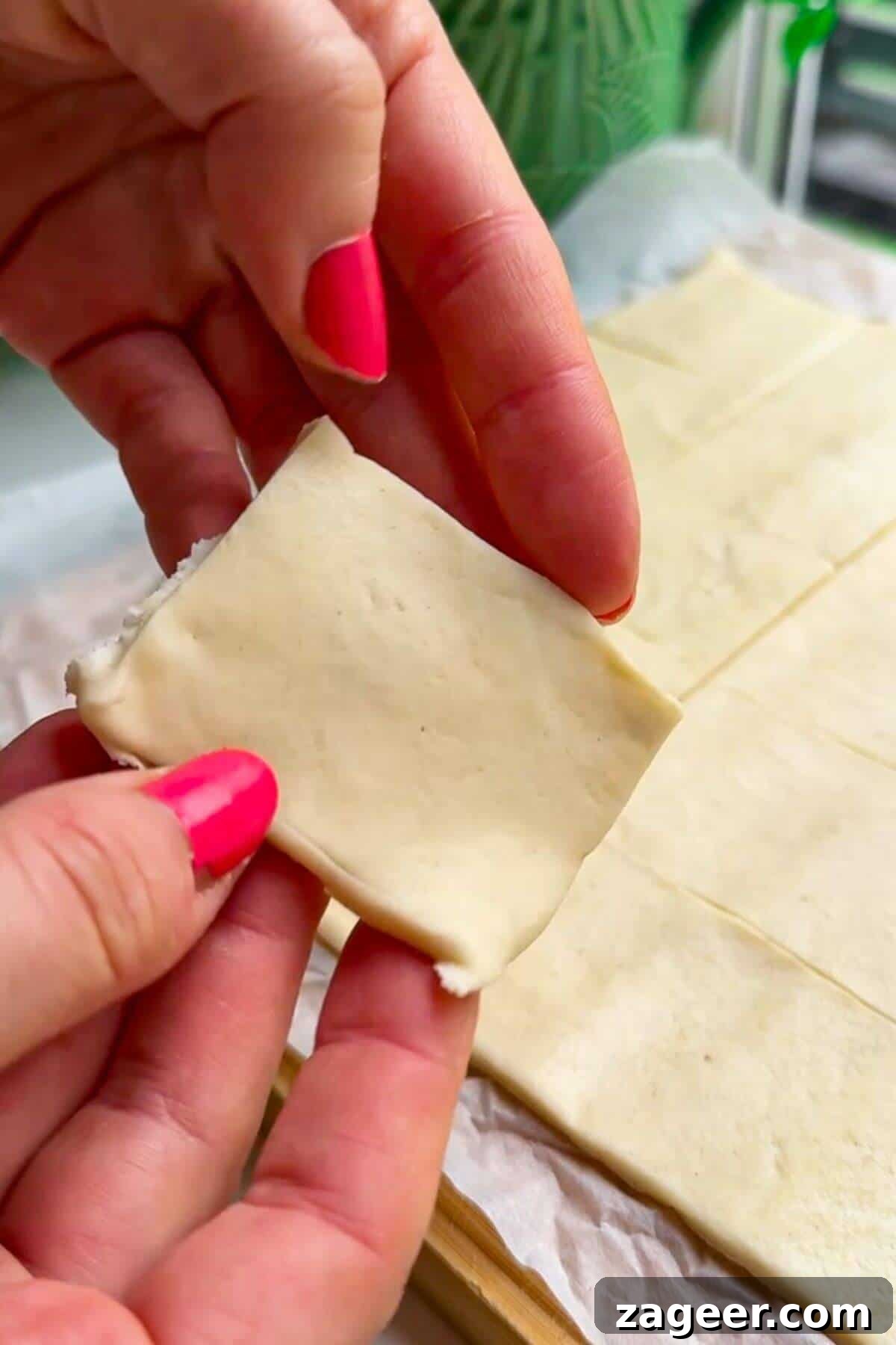 Savory Pesto Ricotta Puff Pastry Bites 5 Holding square of puff pastry.