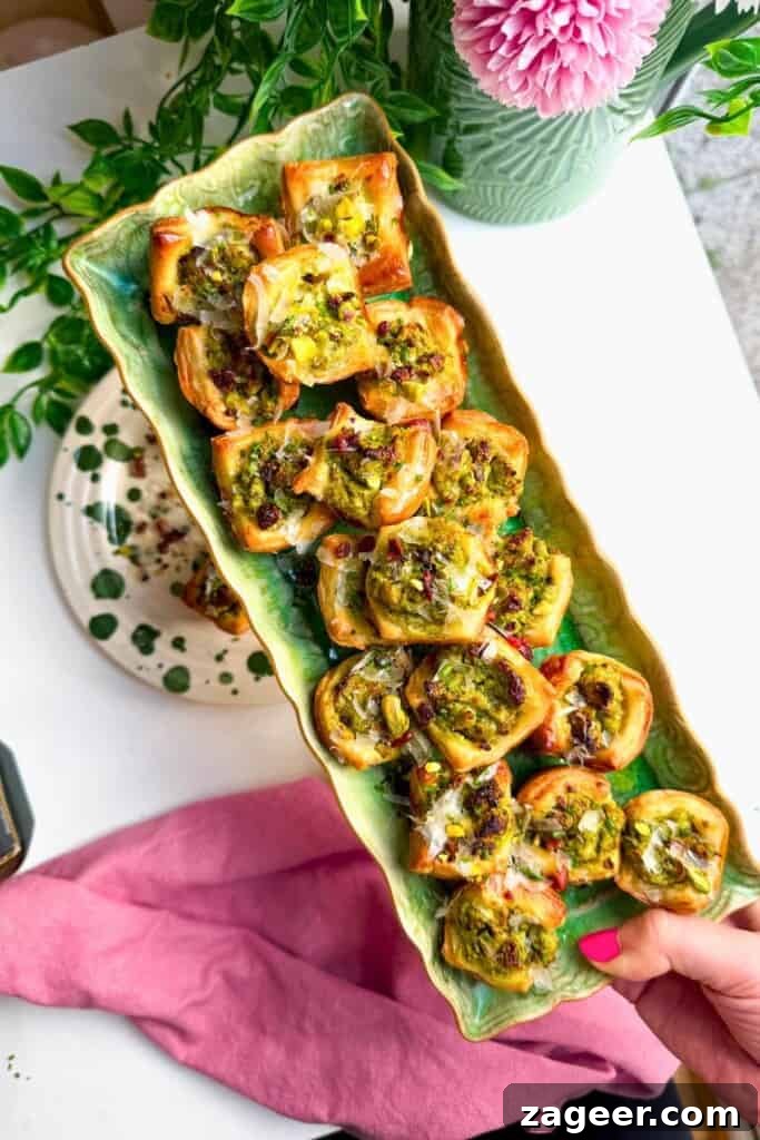 Savory Pesto Ricotta Puff Pastry Bites 9 Pesto ricotta puff pastry cups laid out on serving plates.