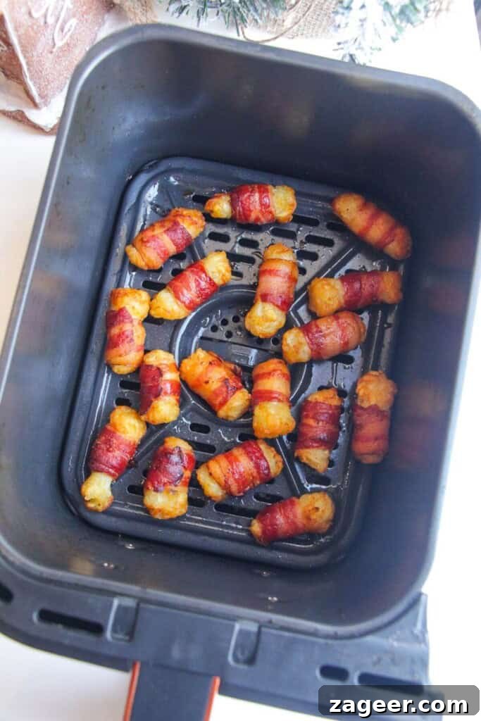 Easy Bacon Wrapped Tots Air Fryer Oven 5 Crispy bacon wrapped tater tots in air fryer basket.
