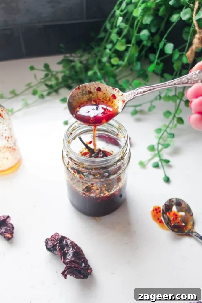 Homemade Basil Pesto So Good So Fast 8 Hot honey drizzling from a silver spoon into a glass jar.