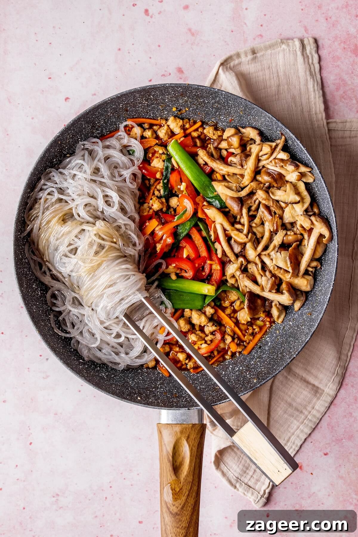 Korean Glass Noodles: A Stir-Fry Sensation 14 Tossing cooked noodles and vegetables with sauce