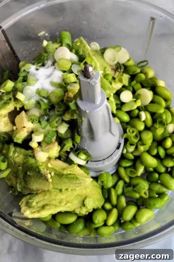 Vibrant Edamame Avocado Hummus 4 Edamame, avocado, spring onion in the bowl of a food processor.