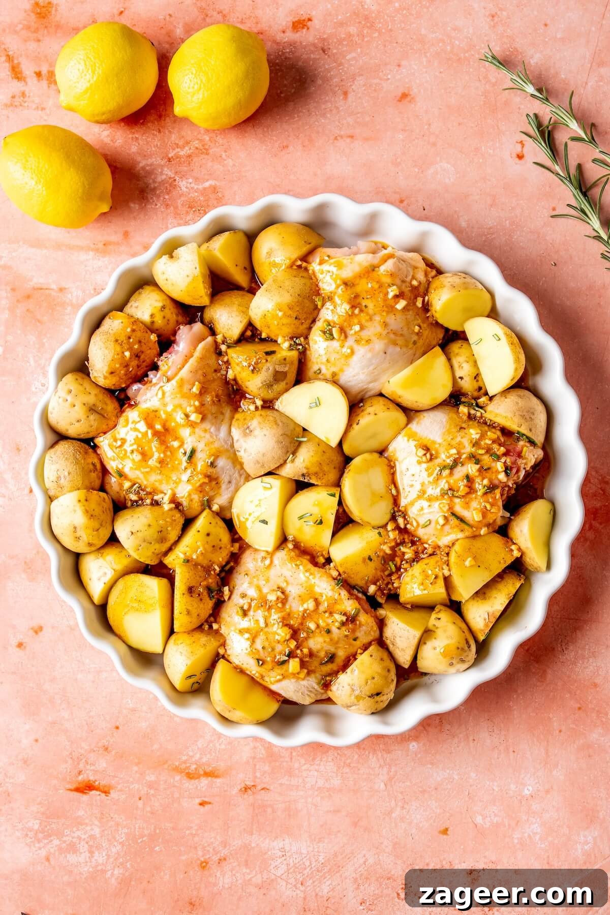 Sheet Pan Lemon Herb Roasted Chicken and Potatoes 8 Pouring lemon herb marinade over chicken and potatoes