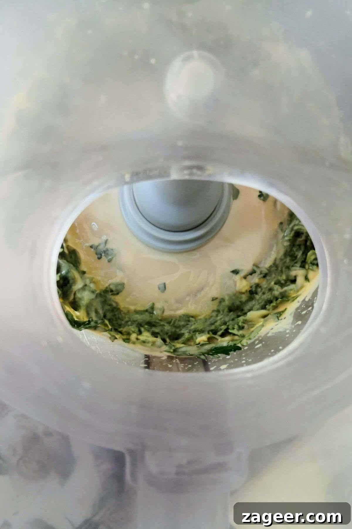 Vibrant 5-Minute Vegan Green Tahini Sauce 5 Green tahini being blitzed in the bowl of a food processor.