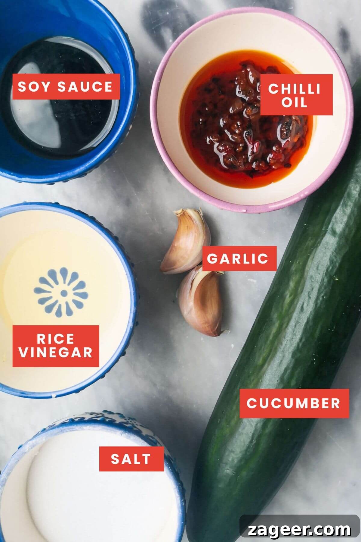 Smacked cucumber salad ingredients on a grey marble background.