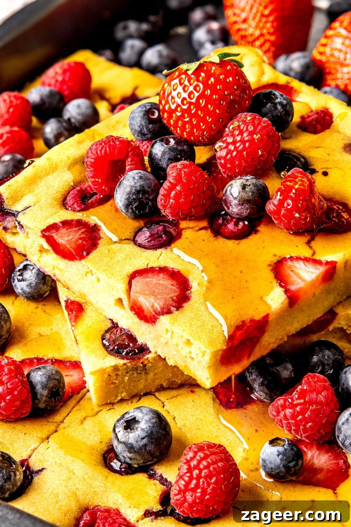 Gluten Free Sheet Pan Pancake Bake 6 Close-up of a square of fluffy gluten-free sheet pan pancake with fresh berries.