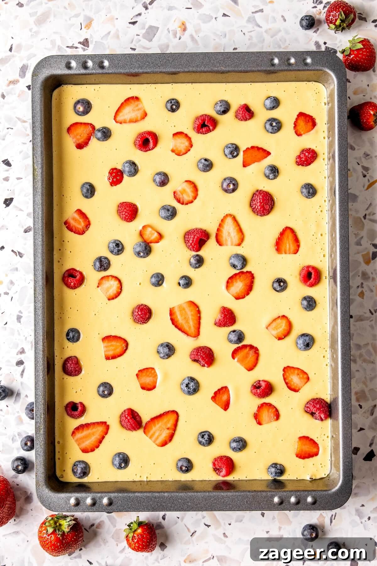 Gluten Free Sheet Pan Pancake Bake 10 Gluten-free sheet pan pancakes served on a plate with fresh fruit and maple syrup.